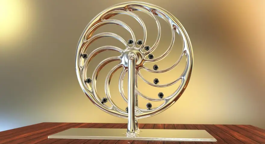 Glänzendes Rad mit schwarzen Kugeln, das an ein Perpetuum mobile erinnert, steht auf einem Holztisch.