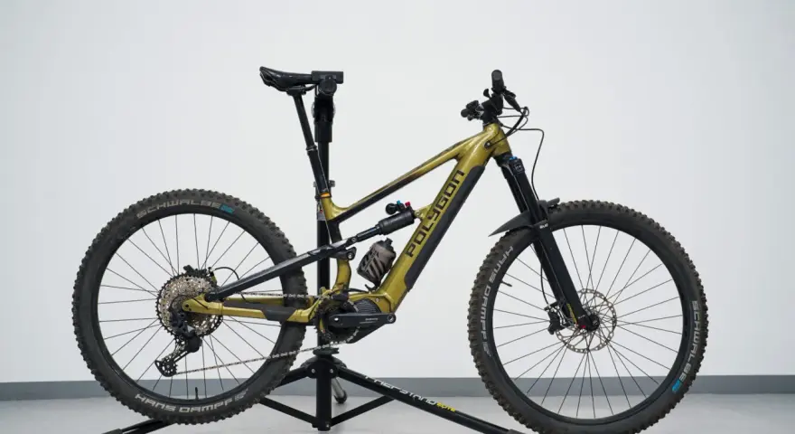A gold Polygon mullet bike with a dropper post, full suspension, and knobby tires, ready for any trail.