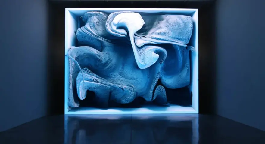 Une oeuvre d'art numérique captivante, aux formes bleutées et texturées, évoquant un nuage ou une vague figée dans un cube lumineux.