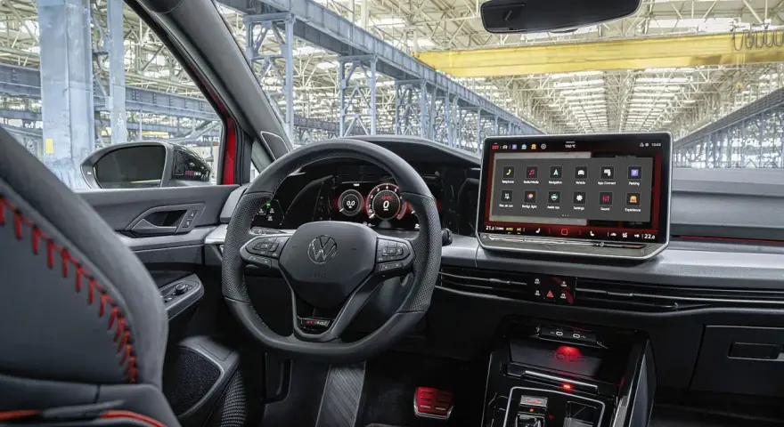Wnętrze samochodu Volkswagen Golf z dużym ekranem dotykowym i cyfrowymi zegarami.