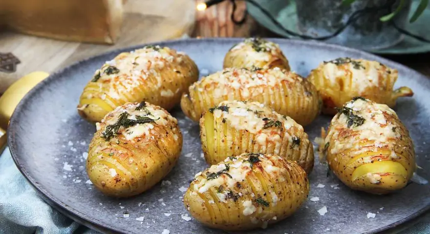 Hasselbackspotatis recept: gyllene, krispiga potatisar med ost och örter, redo att avnjutas.