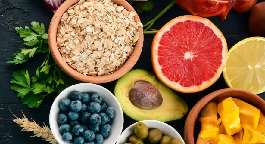 Assortiment de fruits et légumes : flocons d'avoine, myrtilles, avocat, pamplemousse, citron, olives, mangue. Attention aux aliments mauvais pour la flore intestinale.