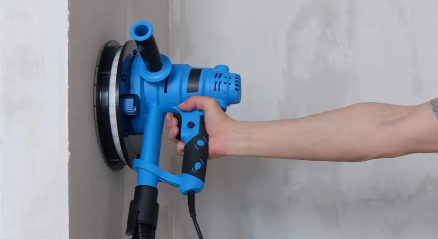 Utensile blu per levigare il muro, ideale per capire come togliere la vernice dal muro.