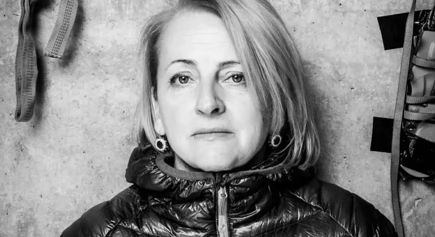 Portret Ewy Berbeki w czarno-białej tonacji, na tle betonowej ściany z elementami wspinaczkowymi.