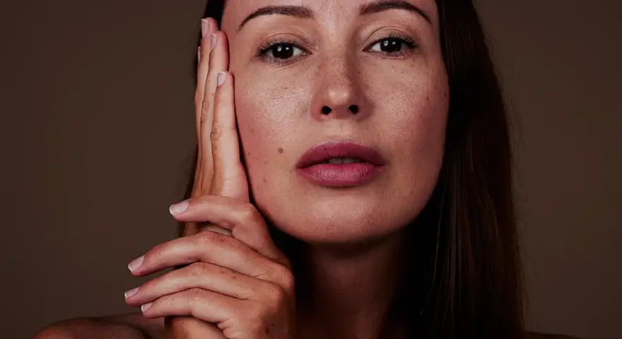 Nahaufnahme einer Frau mit Sommersprossen. Die sanfte glycolic acid wirkung lässt ihre Haut strahlen.