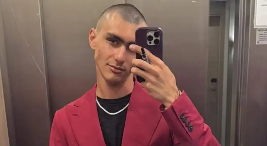 Achille Costacurta, con un look audace e un sorriso enigmatico, sembra affrontare i suoi problemi con stile, sfoggiando un completo fucsia e una collana scintillante.
