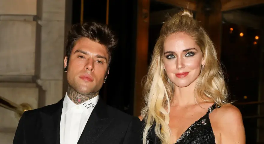 Chiara Ferragni i Fedez pozują do zdjęcia. Ona ma blond włosy upięte w kok, a on tatuaże na szyi.