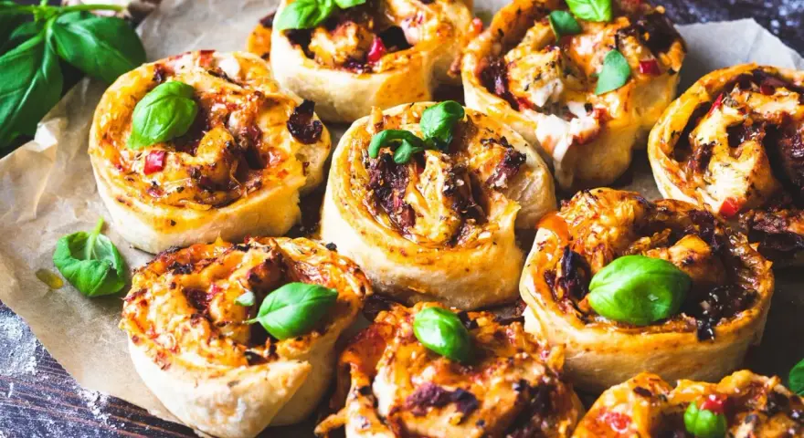 Läckra pizzabullar med kyckling och paprika, perfekta för ett snabbt och enkelt pizzabullar recept. Garnerade med färsk basilika.