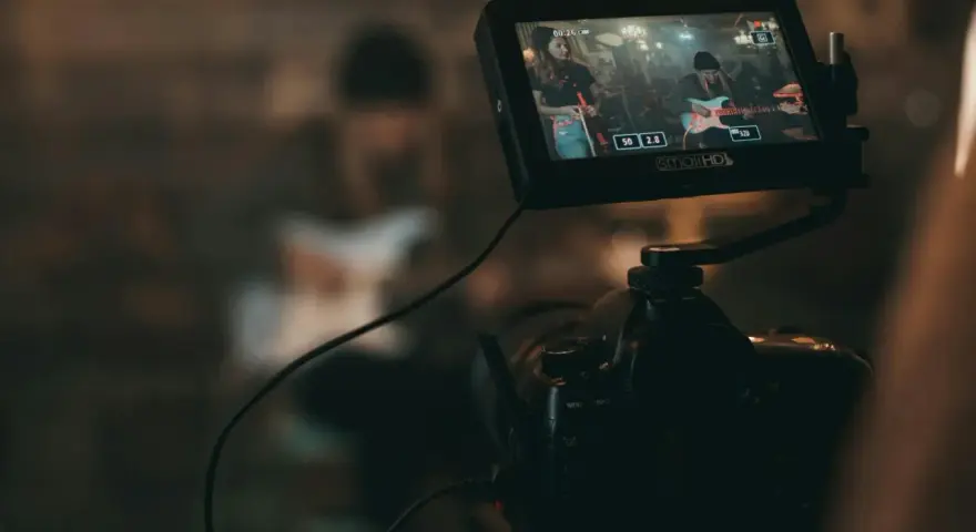 Kamerafilmung einer Band für die Sync-Lizenzierung. Auf dem Monitor ist eine Frau mit Gitarre zu sehen.