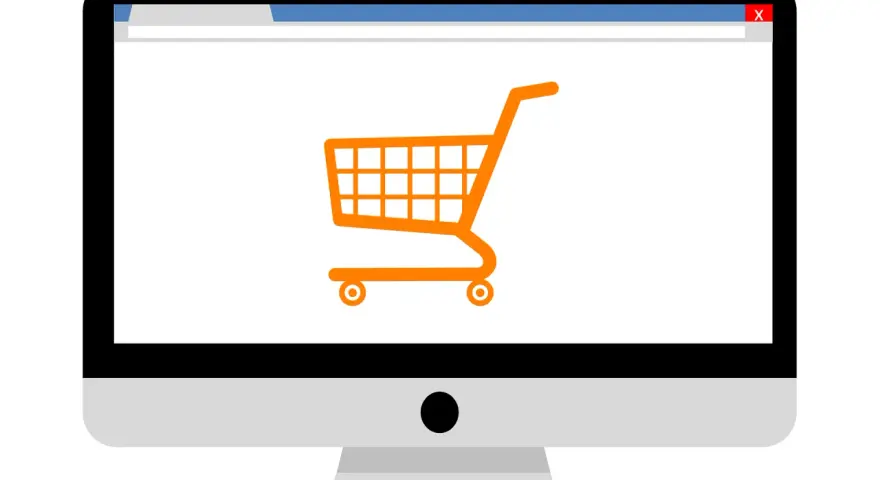 Monitor z ikoną koszyka zakupowego, symbolizujący branżę e-commerce i zakupy online.