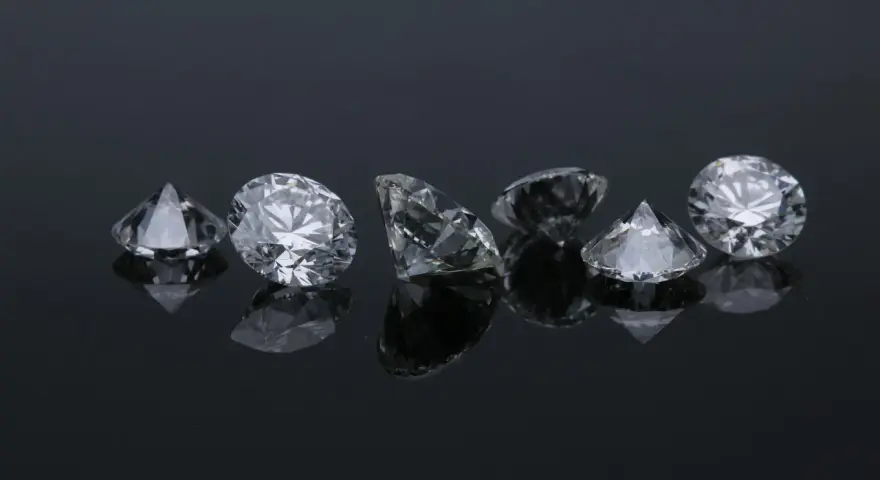 Siedem błyszczących diamentów na czarnym tle. Co oznacza diament na sympatii? Symbol trwałości i piękna, jak te kamienie.