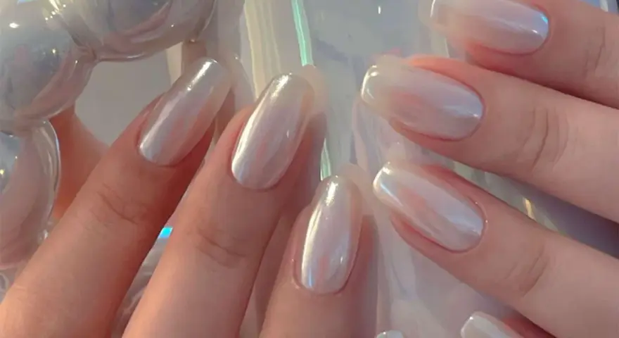 Mani eleganti con unghie a specchio perlate, che riflettono la luce con un effetto iridescente e sofisticato.