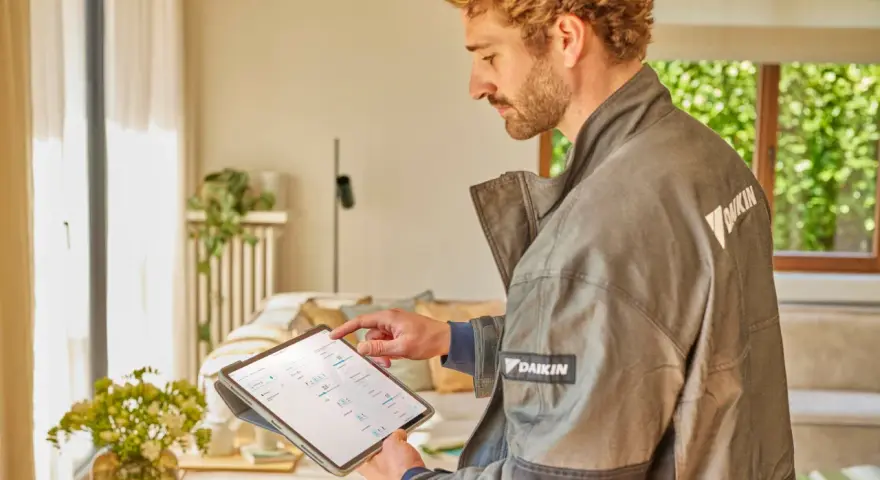 Técnico revisa datos en tablet para el mantenimiento de bomba de calor.