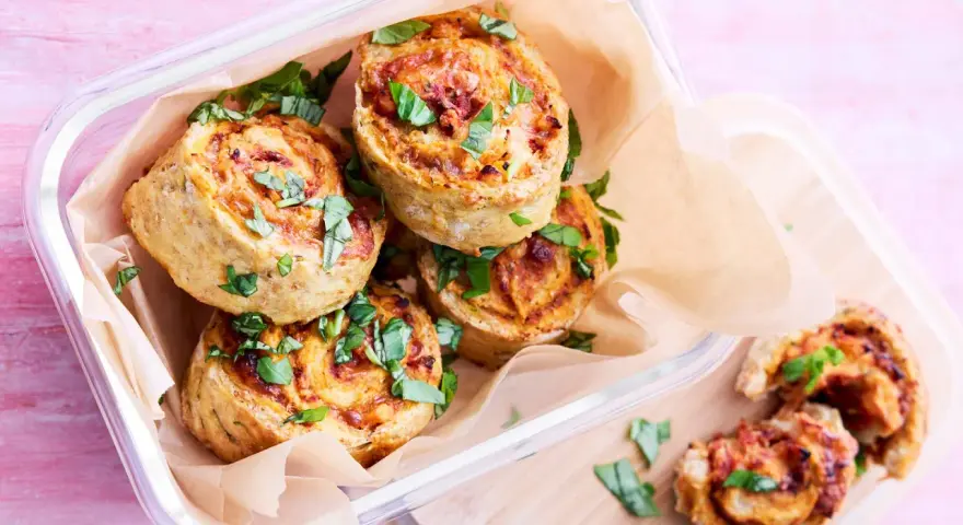Läckra pizza bullar i en glasburk, toppade med färsk basilika. Perfekta för en picknick eller som mellanmål.