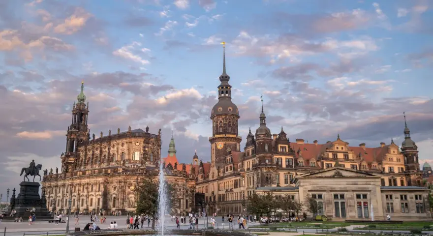 Zamek w Dreźnie z fontanną i pomnikiem konnym na placu. Architektura zachwyca o zachodzie słońca.