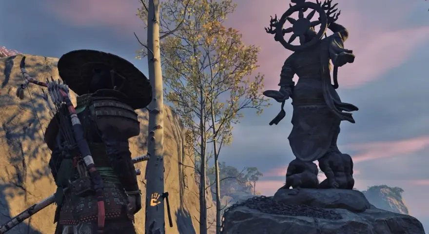 Samuraj przy Kapliczce Popiołów w Ghost of Tsushima. W tle posąg Buddy i drzewa.