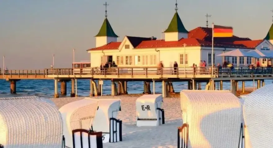 Plaża w Ahlbecku z molo i charakterystycznymi koszami plażowymi. Idealne miejsce na relaks i podziwianie zachodu słońca.