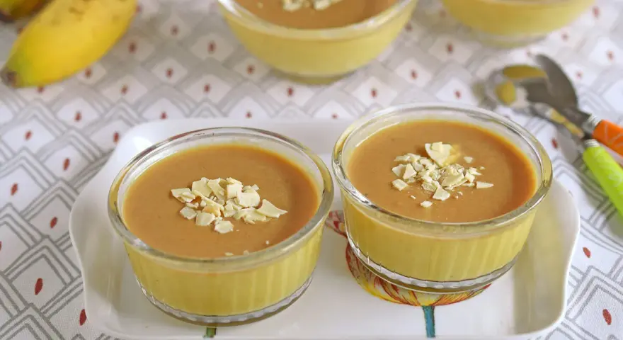 Postres de plátano en copas de cristal, decorados con láminas de almendra.