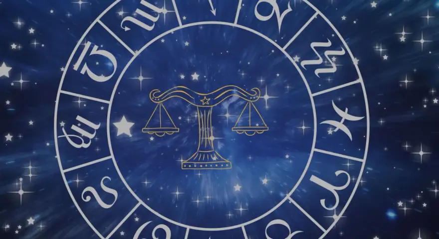 Złoty symbol wagi, jeden z dwunastu znaków zodiaku, na tle gwieździstego, niebieskiego kosmosu.