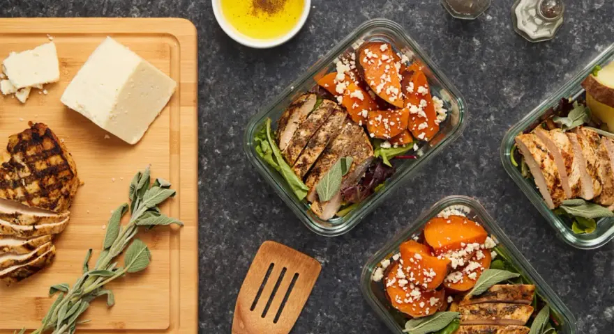 Repas préparés pour manger healthy : poulet grillé, patates douces, fromage et salade.