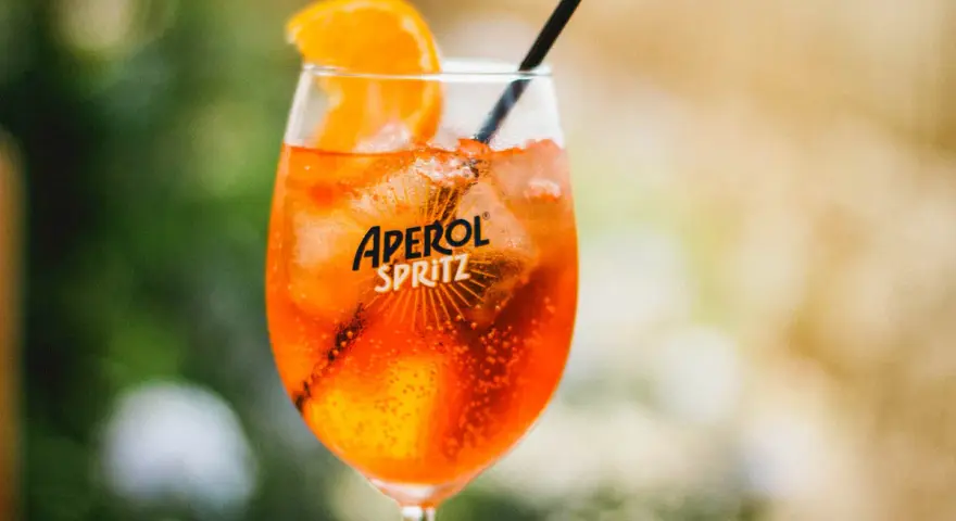 Ett glas med en orange aperol drink utan prosecco, is och en apelsinskiva.