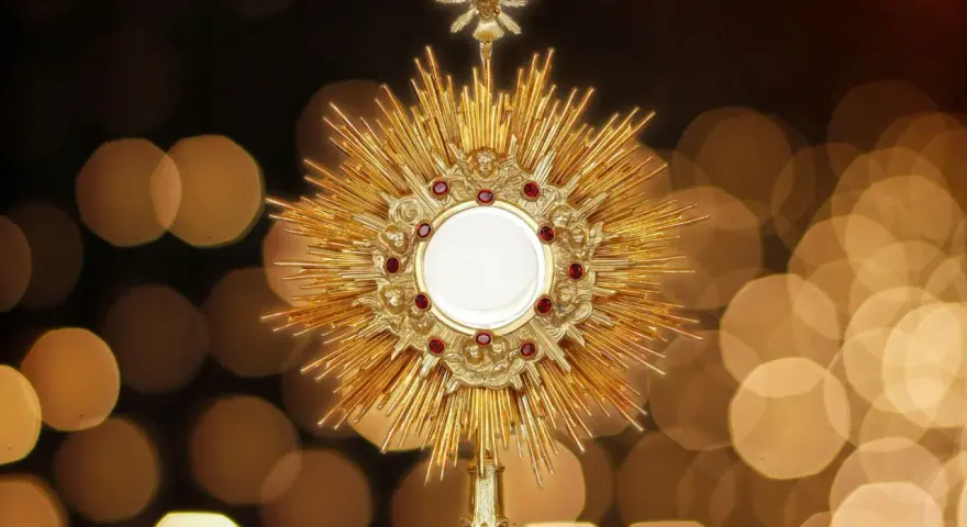 Złota monstrancja z hostią, otoczona promieniami i rubinami, symbolizuje pierwsze piątki miesiąca.
