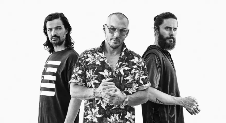 Les membres de Thirty Seconds to Mars posent ensemble, un regard intense sur le visage de Jared Leto.
