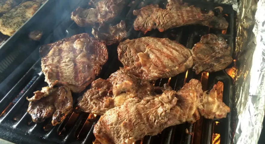 Soczyste kawałki mięsa grillują się na ruszcie, tworząc idealne **churrasco**. Dym unosi się, zapowiadając ucztę.