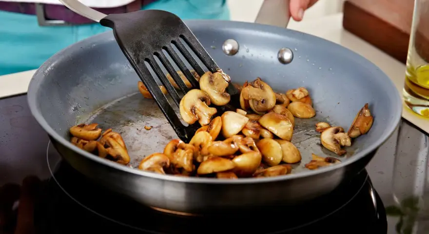 Gebratene Champignons in einer Pfanne, bereit für leckere Champignons Rezepte.