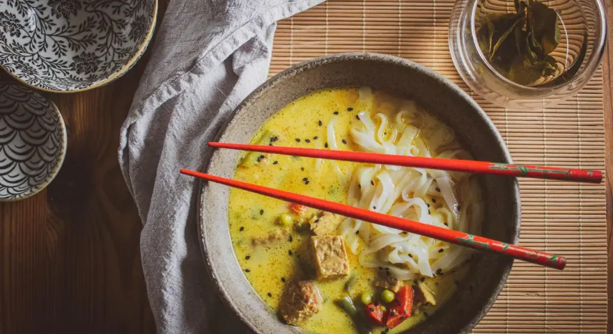 Aksamitna zupa laksa z makaronem ryżowym, tofu i warzywami. Idealny przepis na rozgrzewający posiłek.
