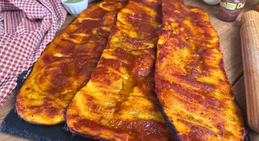 Lingue di pizza sottili e croccanti, condite con salsa rossa e dorate al forno.