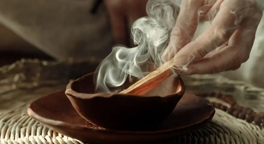 Dym z kadzidła palo santo unosi się z glinianej miseczki. Poznaj, jak palić palo santo, by oczyścić przestrzeń.