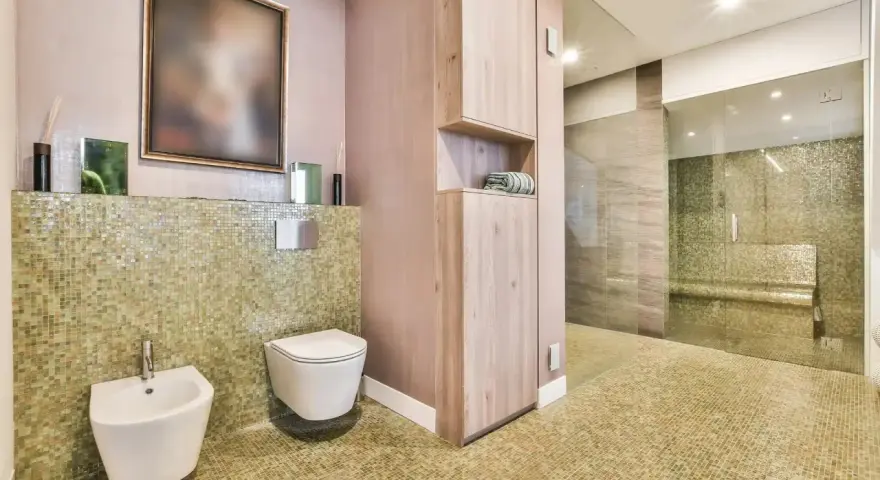 Salle de bain moderne avec bidet et WC suspendu. L'inconvénient du WC suspendu est l'accès au réservoir, caché derrière le mur.