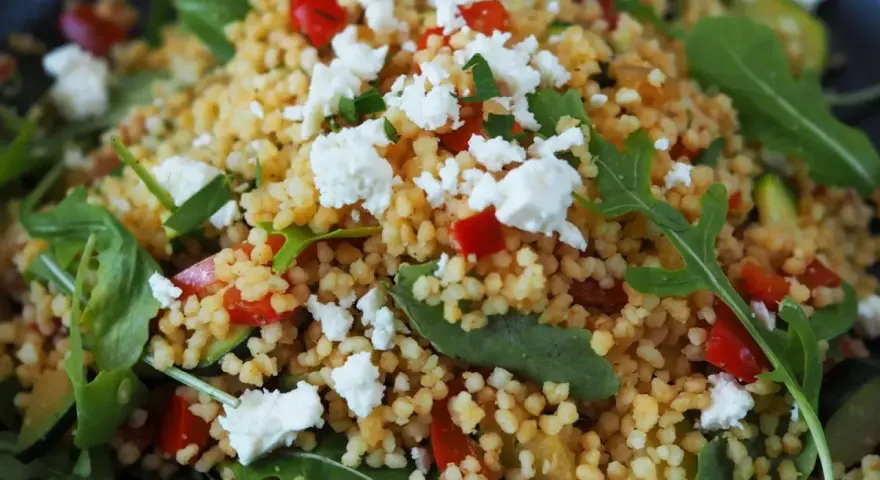 Ein bunter Couscous-Salat mit Feta, roten Paprikawürfeln und Rucola. Frisch und lecker!