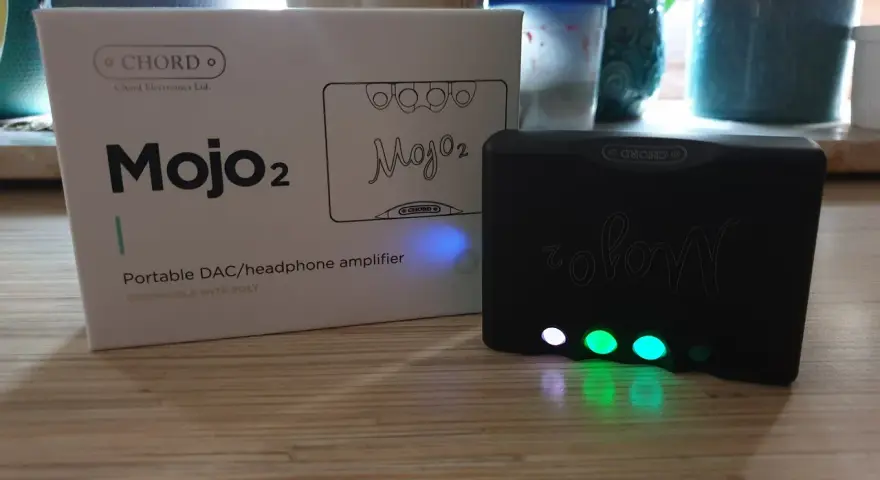 Zestaw Chord Mojo 2: pudełko i czarny wzmacniacz z podświetlanymi przyciskami.