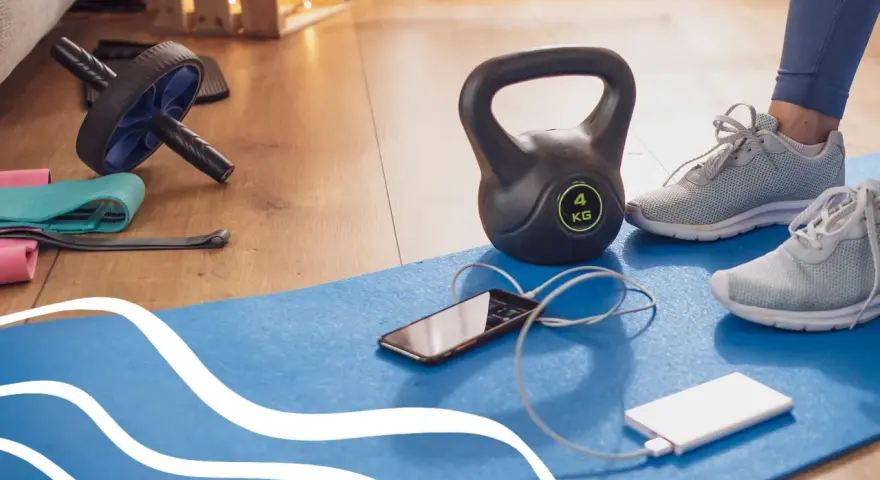 Kettlebell, buty sportowe, telefon i powerbank na macie do ćwiczeń. Gotowy na trening cardio w domu!