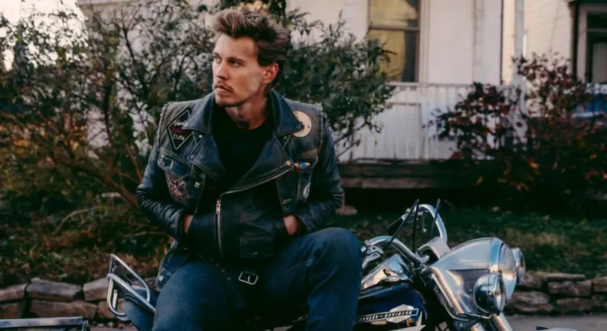 Austin North, protagonista di film e programmi TV, con giacca di pelle e moto.