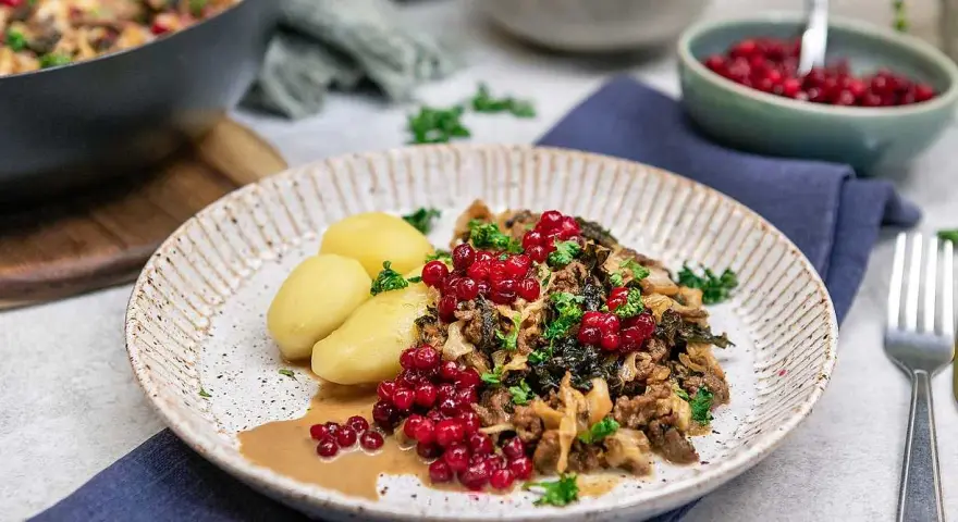 En tallrik med köttfärs och kål, serverad med kokt potatis och lingon. Ett härligt kålmaja recept som ser utsökt ut!