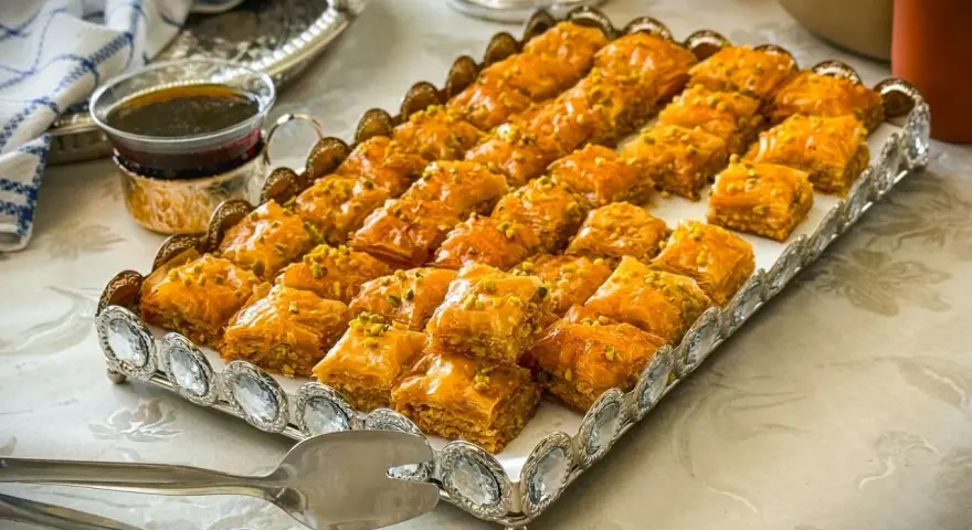 Ein Tablett voller goldbrauner Baklava, bestreut mit Pistazien. Dieses köstliche Baklava-Rezept ist perfekt für jede Feier.