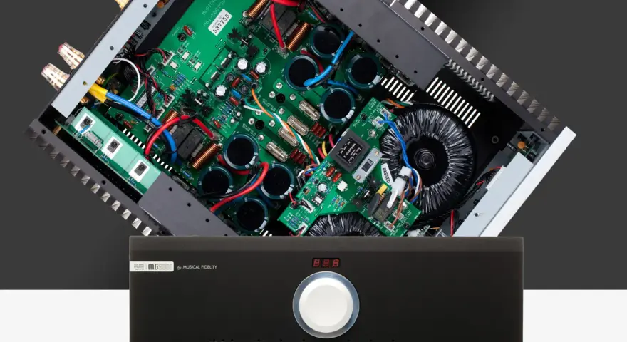 Wnętrze wzmacniacza Musical Fidelity M6 500i z widocznym transformatorem i płytką drukowaną.