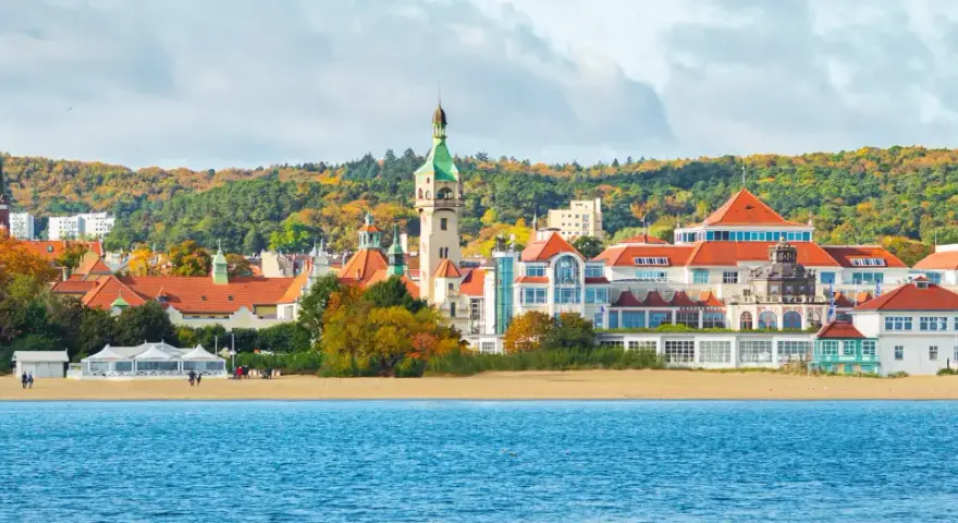 Malownicze budynki i plaża w Sopocie, idealne miejsce, by zobaczyć w Sopocie. W tle jesienne drzewa.