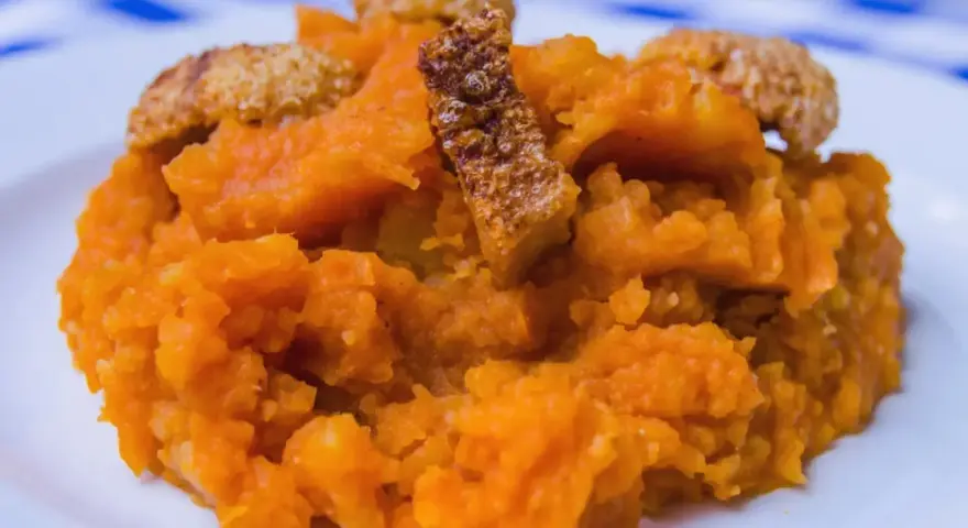 Patatas revolconas cremosas con trozos crujientes de torreznos, un plato tradicional español.