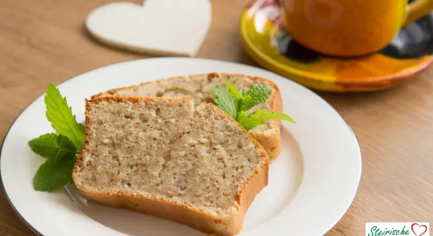 Zwei Scheiben saftiger Becherkuchen mit Joghurt, garniert mit Minze, neben einer Tasse Kaffee.