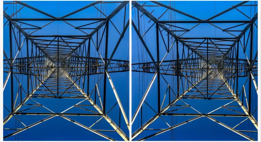 Widok z dołu na kratownicę słupa energetycznego, tworzącą geometryczny wzór na tle błękitnego nieba. To fotografia stereoskopowa.