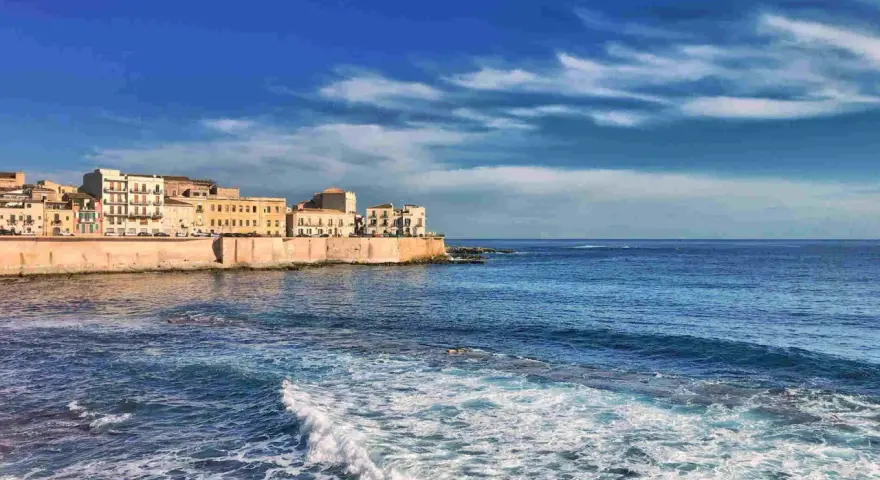 Siracusa: cosa vedere a Siracusa e dintorni in 5 giorni. La costa con palazzi storici e il mare blu.