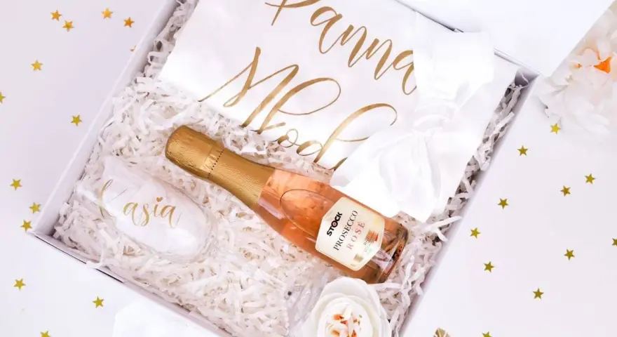 Elegancki prezent na wieczór panieński: kieliszek z imieniem, butelka prosecco i biała szarfa z napisem "Panna Młoda".