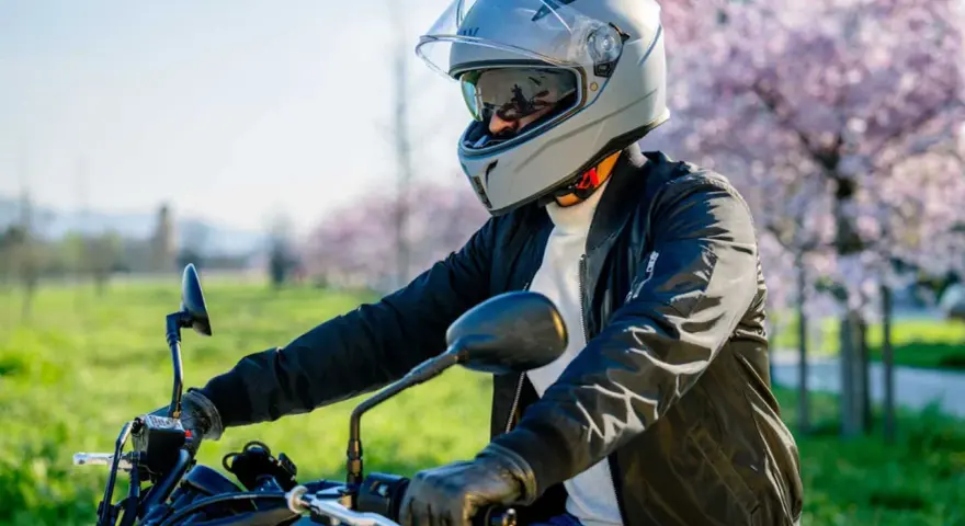 Motociclista con casco grigio, pronto per un giro. La misura testa è perfetta per la sicurezza.