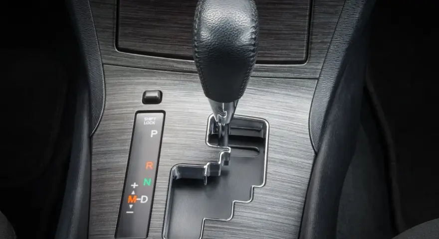 Dźwignia zmiany biegów w samochodzie. Pytanie "tiptronic co to" może dotyczyć tej automatycznej skrzyni biegów z możliwością ręcznej zmiany.