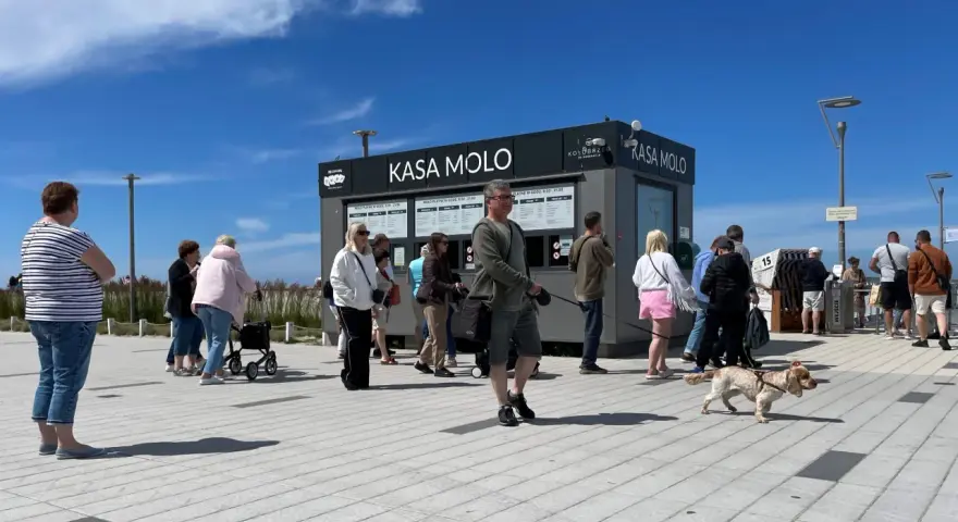Ludzie stojący w kolejce do kasy biletowej "Kasa Molo" w Kołobrzegu.