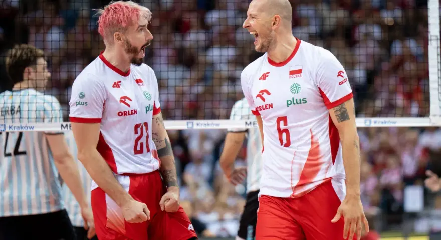 Dwóch zawodników siatkówka polska w biało-czerwonych strojach świętuje punkt. Jeden z różowymi włosami, drugi łysy, obaj krzyczą z radości.